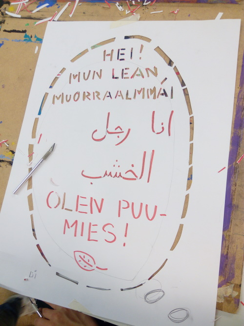 Koululaisten kuvataiteen työ, jossa lukee eri kielillä 