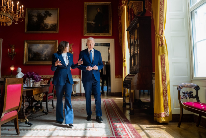 Harris ja Biden keskustelemassa Valkoisen talon koristeellisessa, punaseinäisessä huoneessa.